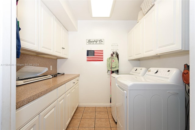 laundry room featuring light tile floors, cabinets, and separate washer and dryer