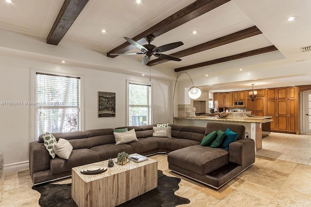 living room featuring ceiling fan, beam ceiling, light tile floors, and a healthy amount of sunlight