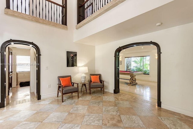 sitting room featuring light tile floors, pool table, and a towering ceiling