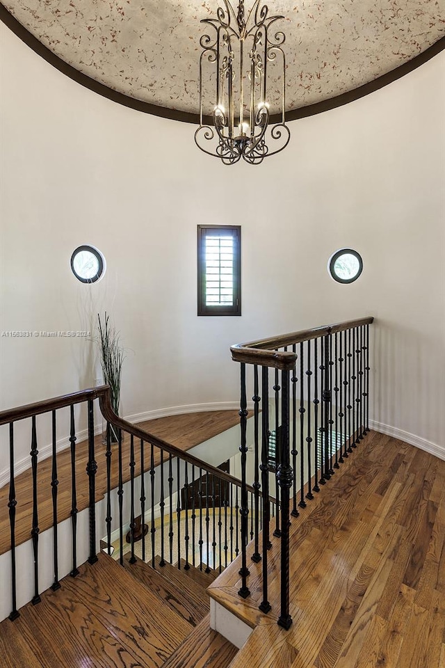 stairway featuring a notable chandelier and dark hardwood / wood-style floors