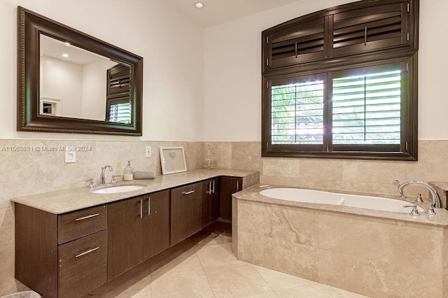 bathroom with a relaxing tiled bath, vanity, and tile floors