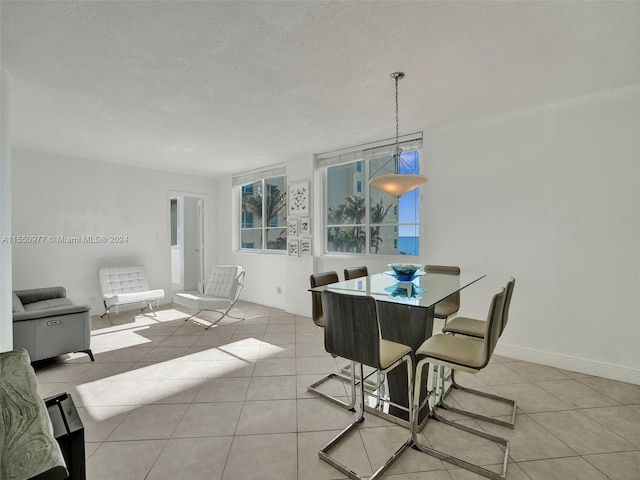 dining space featuring light tile flooring and a textured ceiling