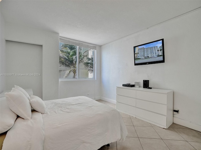 bedroom with a textured ceiling and light tile flooring