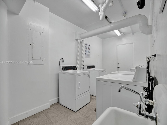 clothes washing area with independent washer and dryer and light tile flooring