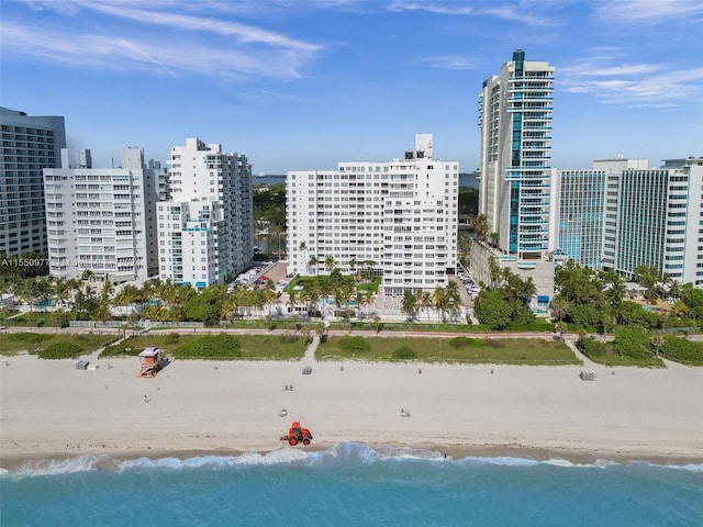 birds eye view of property with a water view and a beach view