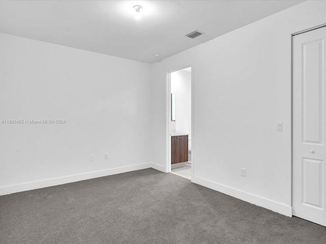 spare room with dark colored carpet