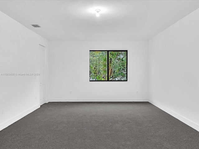 empty room featuring dark colored carpet