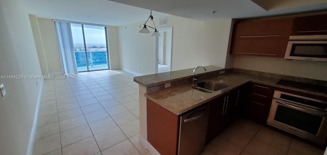 kitchen with sink, kitchen peninsula, oven, a wall of windows, and black electric stovetop