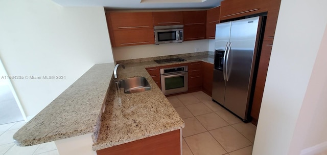 kitchen featuring light tile patterned floors, light stone countertops, appliances with stainless steel finishes, and sink