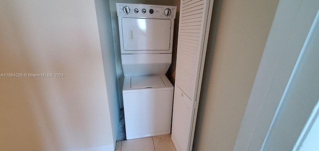 washroom featuring stacked washer and dryer and light tile patterned floors