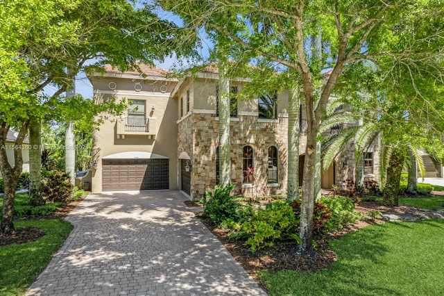 view of front of property featuring a garage, a balcony, and a front yard