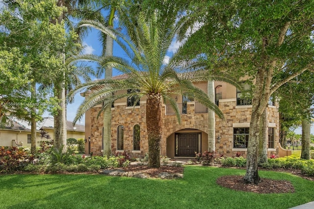 view of front of home featuring a balcony and a front lawn