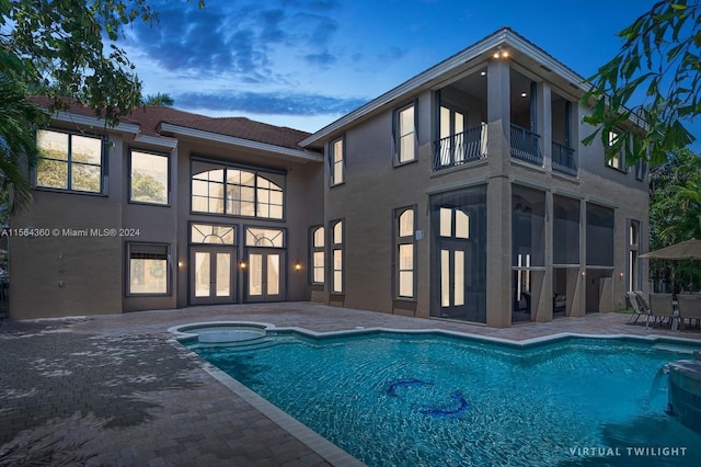 pool at dusk featuring a patio