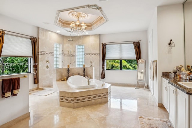 bathroom featuring a notable chandelier, tiled tub, a tray ceiling, tile floors, and vanity