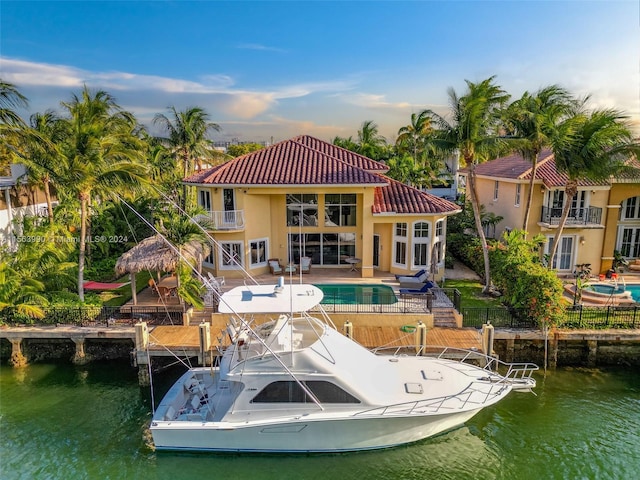 view of dock with a patio, a water view, and a balcony