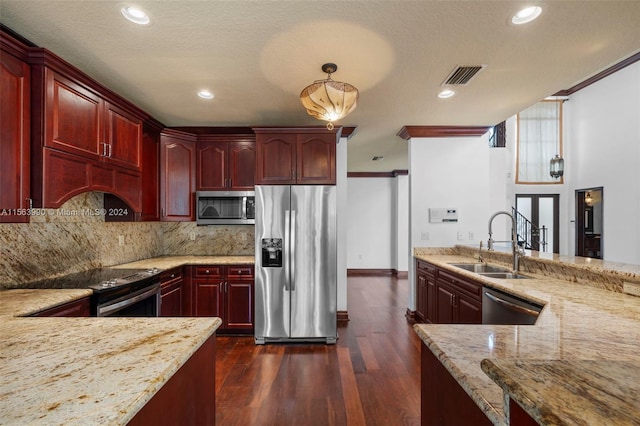 kitchen with light stone countertops, sink, hanging light fixtures, dark hardwood / wood-style flooring, and appliances with stainless steel finishes