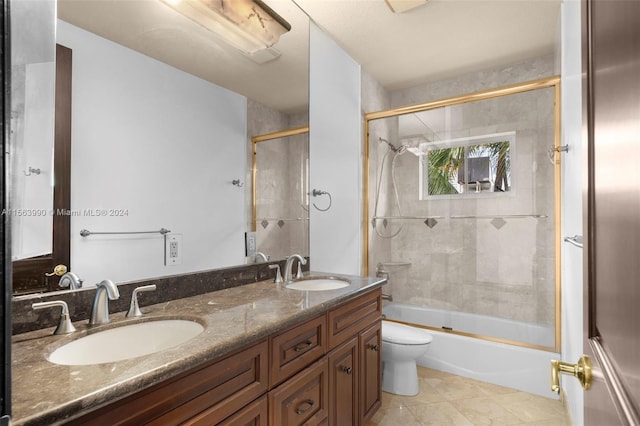 full bathroom with tile patterned flooring, vanity, bath / shower combo with glass door, and toilet