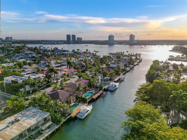 aerial view at dusk featuring a water view