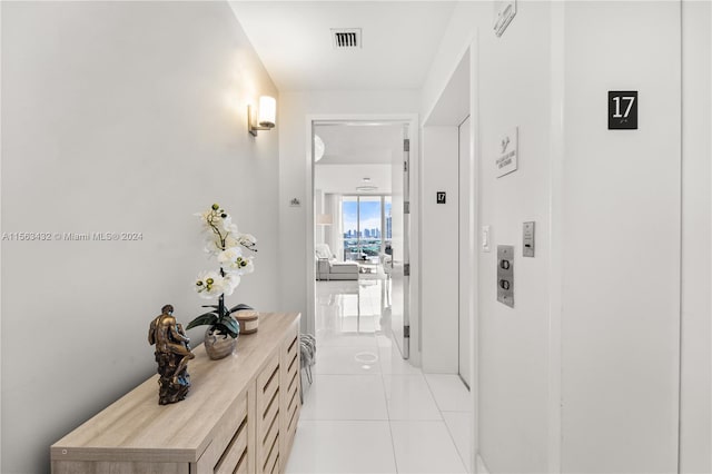 hall featuring visible vents and light tile patterned floors