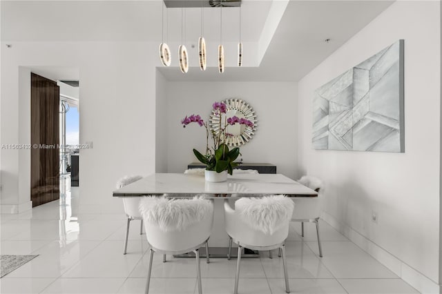 dining room featuring breakfast area, light tile patterned flooring, and baseboards