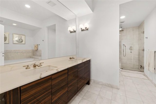 bathroom with double vanity, a shower stall, visible vents, and a sink