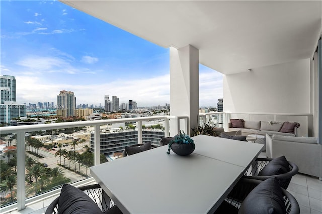 balcony featuring outdoor dining space, outdoor lounge area, and a city view