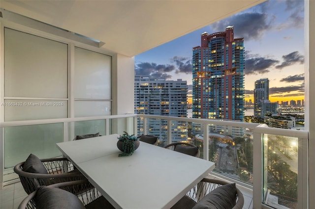 balcony with outdoor dining space and a city view