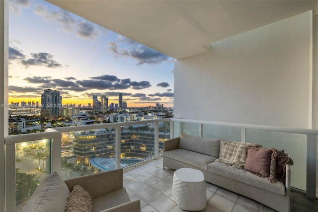 balcony at dusk featuring a view of city and an outdoor hangout area