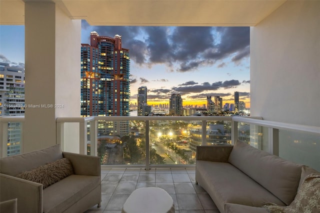 balcony at dusk featuring a city view