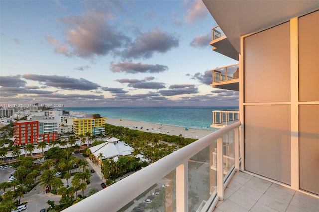 balcony featuring a view of the beach and a water view