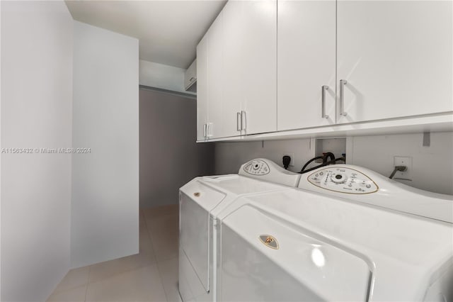 washroom with separate washer and dryer, light tile patterned flooring, and cabinet space