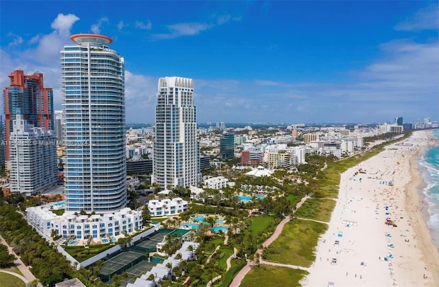 drone / aerial view featuring a view of city, a beach view, and a water view