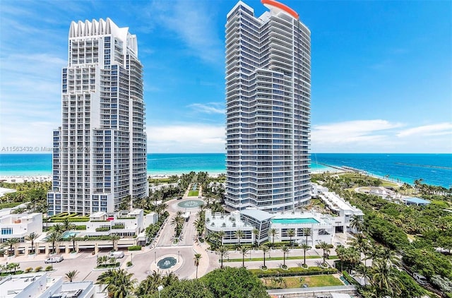 view of building exterior featuring a water view and a view of the beach