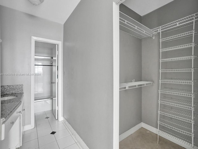 walk in closet with sink and light tile floors