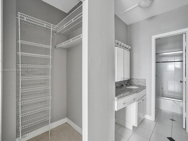 spacious closet with sink and light tile flooring