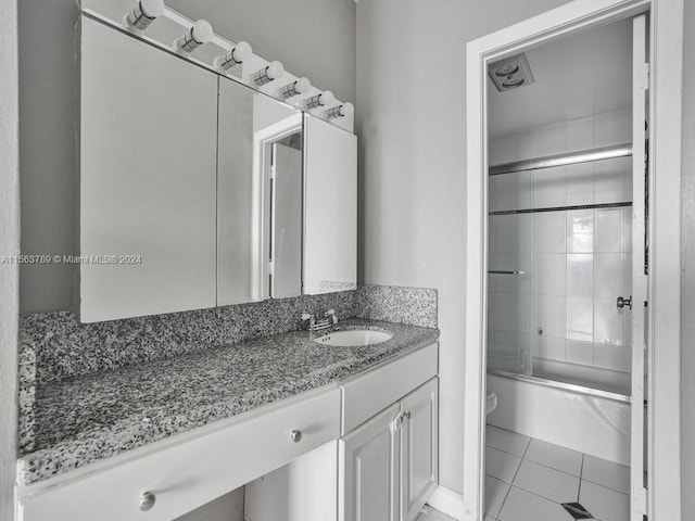 full bathroom with vanity with extensive cabinet space, toilet, shower / bath combination with glass door, and tile flooring