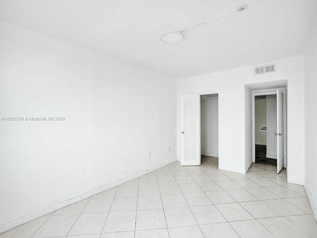 unfurnished bedroom featuring light tile floors