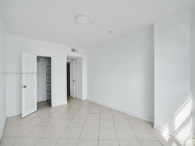 unfurnished bedroom featuring light tile floors