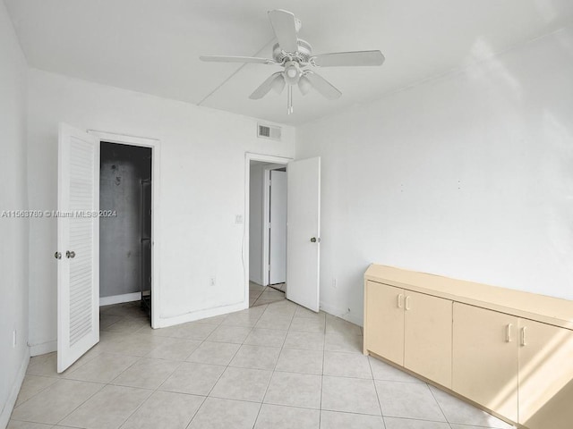 unfurnished bedroom with ceiling fan and light tile floors