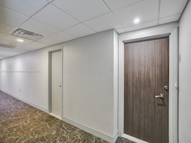 hall featuring a paneled ceiling