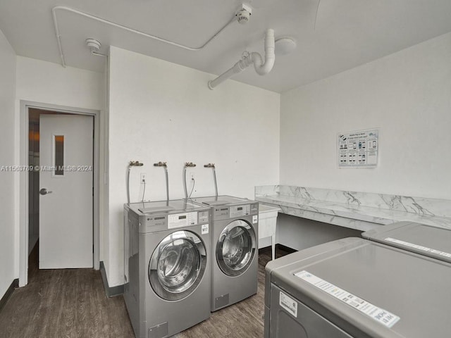 laundry room featuring washer and clothes dryer and dark hardwood / wood-style flooring