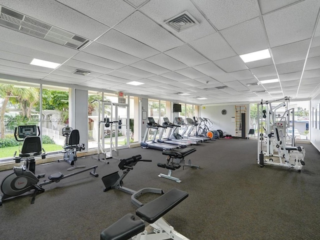 exercise room with a paneled ceiling and carpet