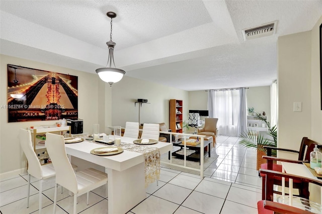 dining space with visible vents, a textured ceiling, and light tile patterned floors