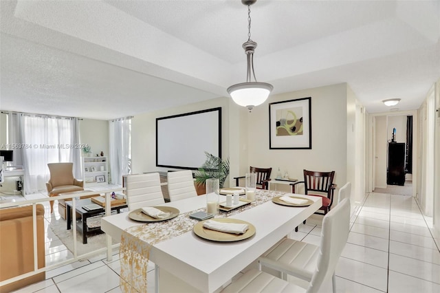 dining space featuring light tile patterned floors and a textured ceiling