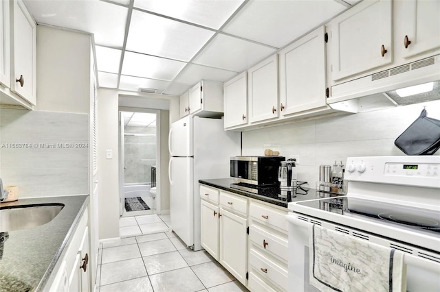 kitchen featuring a paneled ceiling, white range with electric cooktop, light tile patterned floors, and white cabinetry