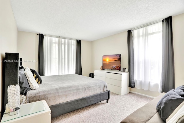 bedroom featuring light colored carpet and a textured ceiling