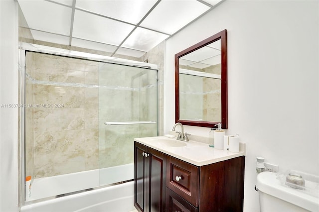 full bathroom with vanity, bath / shower combo with glass door, and toilet