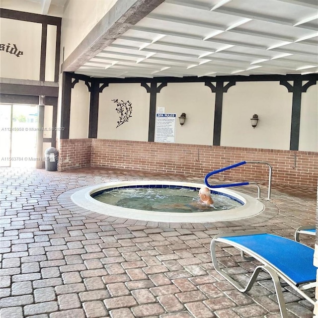 view of swimming pool featuring an indoor in ground hot tub and a patio area