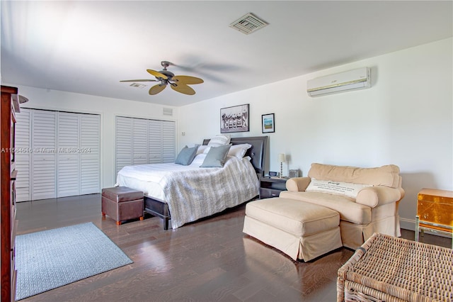 bedroom with multiple closets, a wall unit AC, ceiling fan, and dark hardwood / wood-style floors