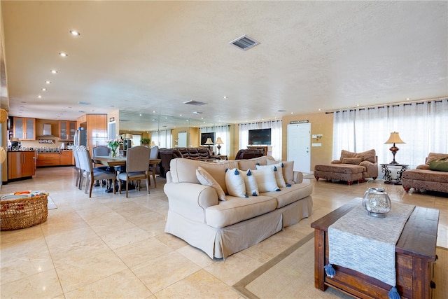 living room featuring a textured ceiling and light tile flooring